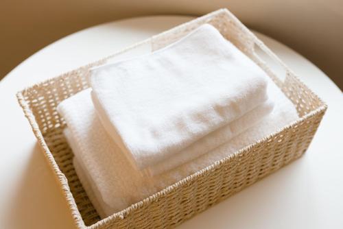 a basket of white napkins on a white plate at B&B MIKAWA Info Centre - Kanazawa Fish Harbour in Kanazawa
