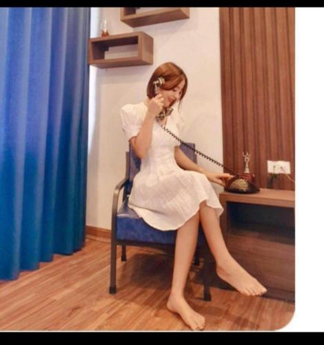 a woman sitting in a chair talking on a cell phone at Sapa Eco Villas & Spa in Sa Pa