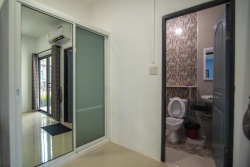 uma casa de banho com um WC e uma porta de vidro em G Place em Sai Yok