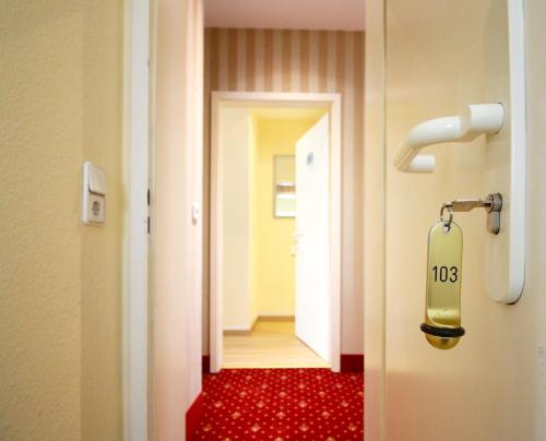 a room with a door with a sign on it at Hotel Am Mühlenteich in Schwelm