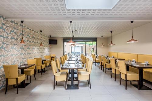 a dining room with tables and yellow chairs at Sure Hotel by Best Western Reims Nord in Reims