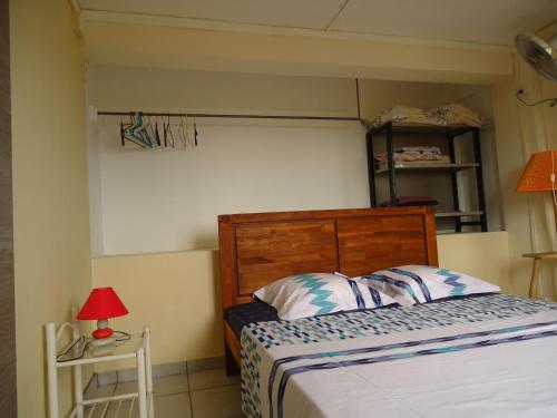 - une chambre avec un lit et une table avec une lampe dans l'établissement villa cocotiers, à Sainte-Marie
