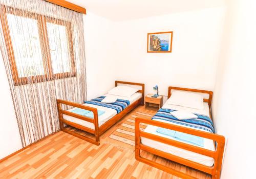 two twin beds in a room with a window at Apartment Tia in Lun