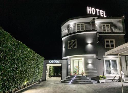 een hotel 's nachts met trappen die naar het hotel leiden bij Hotel Trionfal in Qualiano