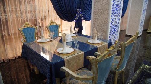 een blauwe tafel met twee stoelen en kaarsen erop bij Sumaya Hotel in Samarkand