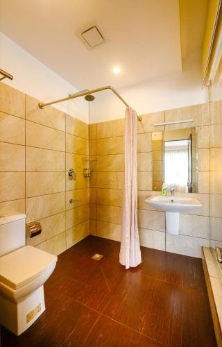 a bathroom with a toilet and a sink at Cyrus Lake Haven in Alleppey