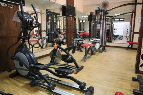 a gym with several treadmills and exercise bikes at Panacea Suites Hotel in Borg El Arab
