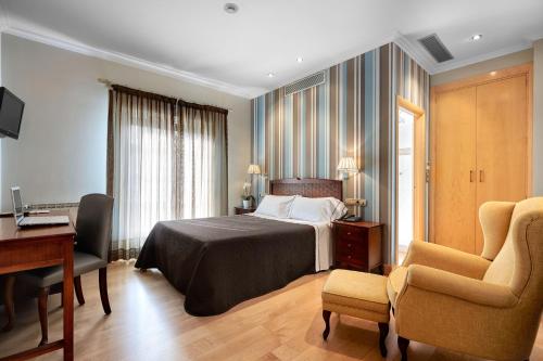 a hotel room with a bed and a desk and chairs at Atalaia in Irún