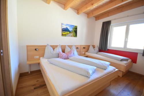 two beds in a room with two windows at Chalet Gonda inklusive Premiumcard in Galtür