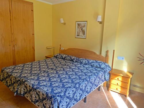 a bedroom with a blue bed and a night stand at Hotel Antic in Ordino