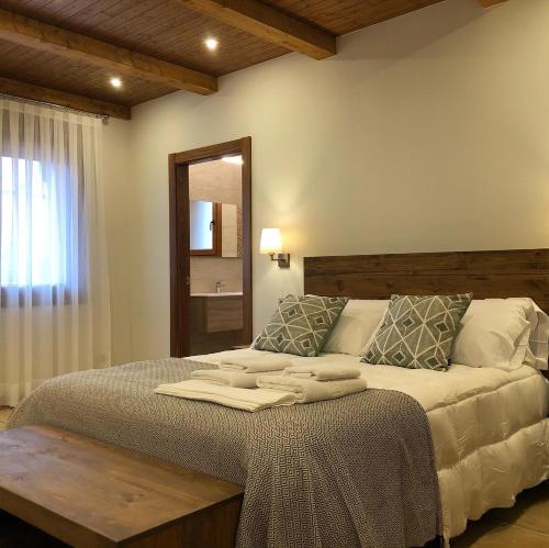 a bedroom with a large bed and a mirror at La Mañica in La Vilueña