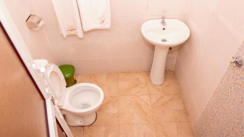 a small bathroom with a toilet and a sink at Sheratton Regency Hotel Nairobi in Nairobi