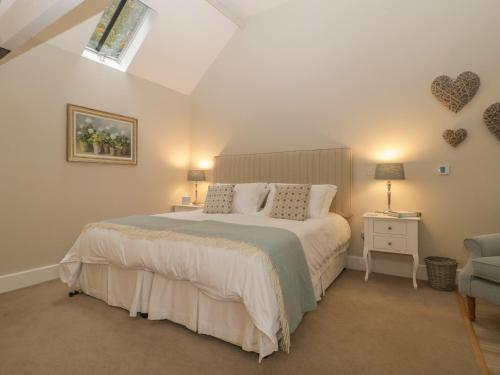 a bedroom with a bed and two lamps and a chair at Cow Drove Cottage in Salisbury