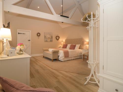 a bedroom with a bed and a couch and a table at Barn Owl Cottage in Salisbury