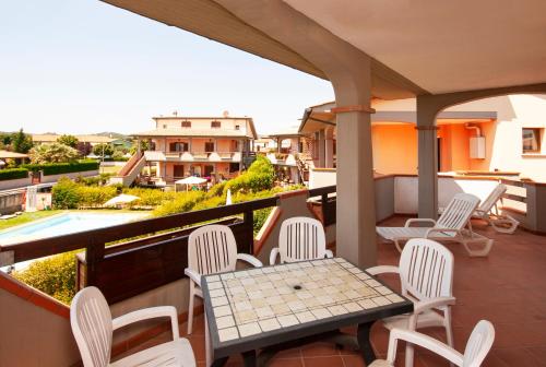 un patio con tavolo e sedie sul balcone. di Follonica Apartments a Follonica