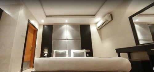 a bedroom with a large bed and a mirror at Nawara MEDICAL CITY in Riyadh