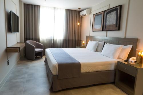 a hotel room with a bed and a television at Ritz Leblon in Rio de Janeiro