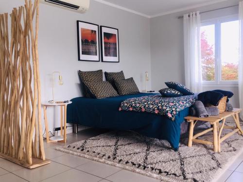 a bedroom with a blue bed and a window at Chambre d'hôtes Ama in Pompignac