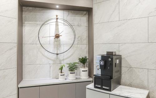 a coffee machine sitting on a counter with a clock at JJ Hotel in Seongnam