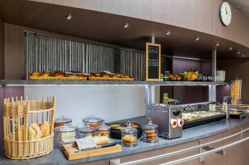 a bakery with a counter with pastries and bread at Sure Hotel by Best Western Reims Nord in Reims