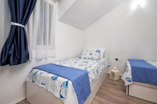 a small bedroom with two beds and a window at Holiday home Beyla in Pučišća