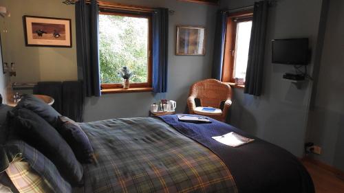 a bedroom with a bed and a window and a television at Invercassley Cottage B & B Suite in Lairg