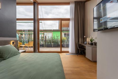 a bedroom with a bed and a large window at Habitat Guest House in Trento