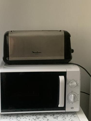 a toaster oven sitting on top of a microwave at Chambre d'hôtes THE YELLOW CUBE in Aubière