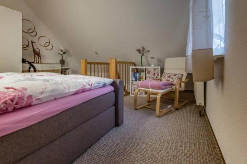 ein Schlafzimmer mit einem Bett, einem Stuhl und einem Fenster in der Unterkunft Weide - gemütliches Ferienhaus am Anger in Kloster, Insel Hiddensee in Kloster