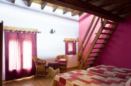 a bedroom with a bed and purple walls at Casa Rural La Pinocha in Sigüenza