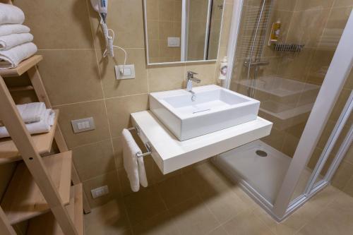 a bathroom with a white sink and a shower at Habitat Guest House in Trento