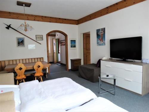 a living room with a television and a couch at Hotel Bündnerhof in Davos