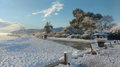 a beach covered in snow with a boat on it at CASA LELA 1...όπως μια φορά...like once in Míloi