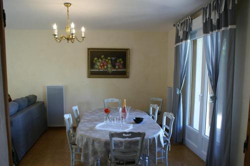 une salle à manger avec une table, des chaises et un lustre dans l'établissement Entre Phare et Moulin, à Verzenay
