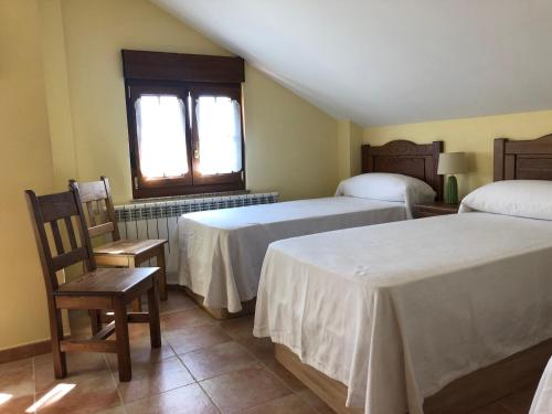 QuijasにあるVilla La Encinaのベッドルーム1室(ベッド2台、椅子、窓付)