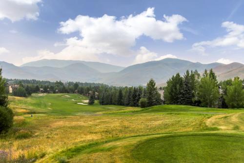 a green golf course with mountains in the background at Dollar Meadows 1388 in Sun Valley
