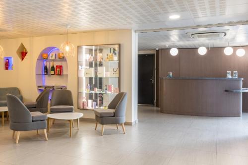 a waiting room with chairs and a table and a counter at Sure Hotel by Best Western Reims Nord in Reims