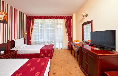 een hotelkamer met 2 bedden en een flatscreen-tv bij Karolina Hotel in Sunny Beach
