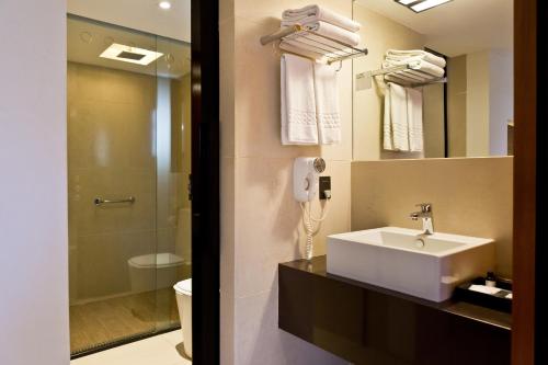 a bathroom with a sink and a phone on the wall at Ritz Leblon in Rio de Janeiro