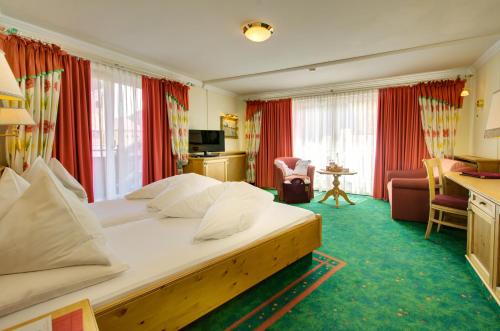 a hotel room with a large bed in a room at Boutique-Hotel Bauer in Saalbach-Hinterglemm