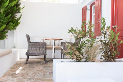 a patio with a chair and a table with plants at Stelia Mare Boutique Hotel in Naousa