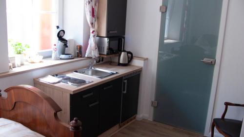 a small kitchen with a sink and a stove at Apartmenthaus "Zum Birnbaum" in Roßtal