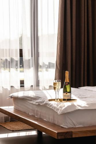 a bottle of wine and a glass on a bed at Sofia Hotel in Rivne