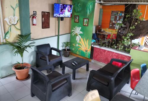 ein Restaurant mit Stühlen und einem TV in einem Zimmer in der Unterkunft Chambres en Ville in David