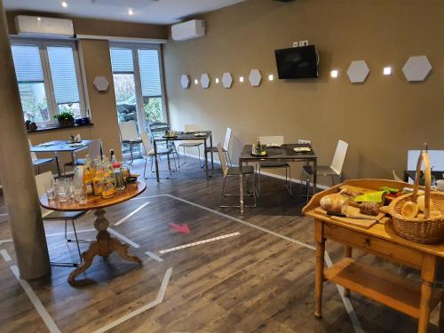 een eetkamer met tafels en stoelen en een tv bij Burgers Hotel in Kippenheim