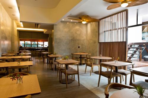 a restaurant with wooden tables and chairs and windows at Ritz Leblon in Rio de Janeiro