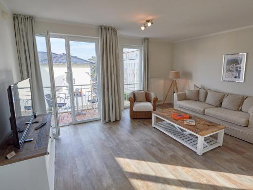ein Wohnzimmer mit einem Sofa und einem TV in der Unterkunft Residenz "bel-vital" Binz - WG28 mit kleinem Meerblick und Balkon in Binz