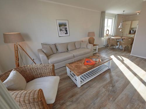 ein Wohnzimmer mit einem Sofa und einem Couchtisch in der Unterkunft Residenz "bel-vital" Binz - WG28 mit kleinem Meerblick und Balkon in Binz