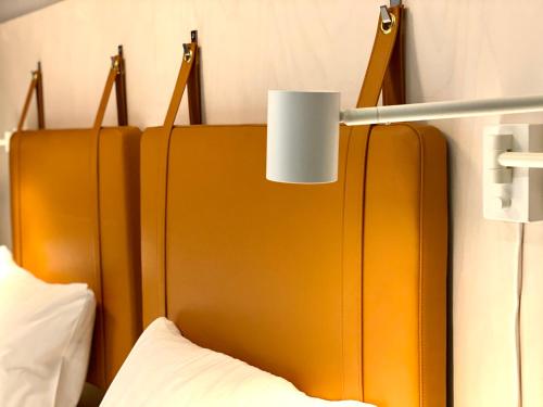 a large orange headboard with a light above a bed at Moment Hotels in Malmö