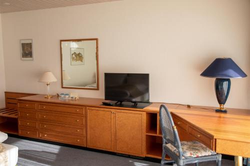a living room with a wooden dresser with a television on it at Alpenlodge Val Gronda in Obersaxen